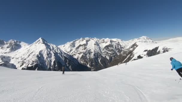 Alpine skier skiing short swings on ski slope on sunny winter day
