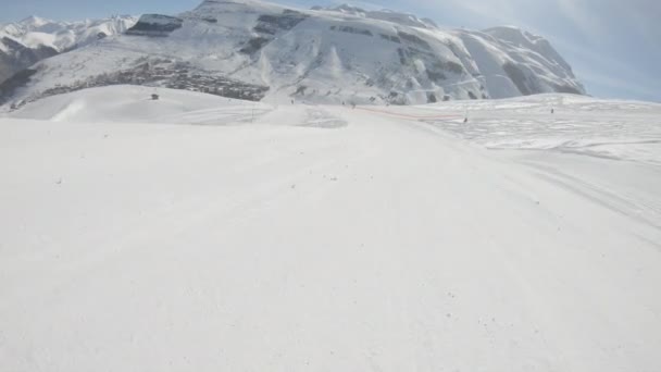 スキーヤーはすぐに山の斜面に対して晴れた日のスキーのルートに下る — ストック動画