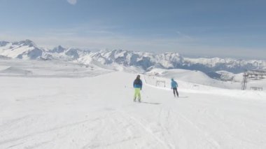 İki Alp kayakçı hızlı dağ yamacında gidiyor