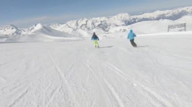 İki Alp kayakçı hızlı dağ yamacında gidiyor