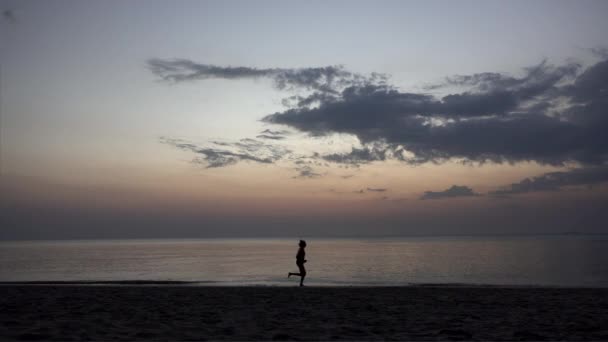 Silueta Del Hombre Corriendo Por Playa Atardecer — Vídeo de stock