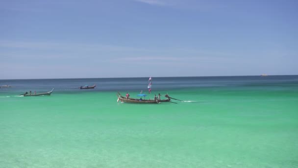 在阳光灿烂的日子 游船或游船在热带海滩的海面上漂流 — 图库视频影像