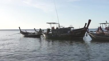 Tayland 'da sakin suda dinlenen tahta uzun kuyruklu tekneler.