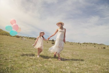 Genç anne ve kızı doğa parkında eğleniyorlar.