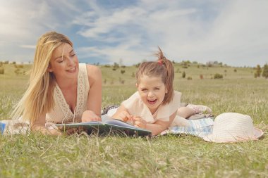 Genç anne ve kızı doğa parkında eğleniyorlar.