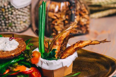 Kızarmış küçük balığın sağlıklı ve lezzetli bir salatayla yakın çekimi..