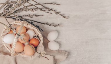 Sepette Paskalya yumurtaları ve gri arka planda söğüt dalları