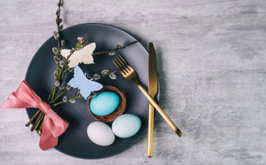 Gri plakalı Paskalya masası ve gri ahşap masa üzerinde mavi yumurta.. 