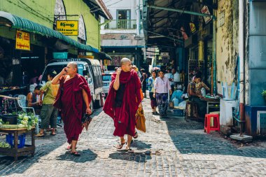 Yangon, Myanmar - FEB 19th 2014: Monks walk and shop in Bogyoke  clipart