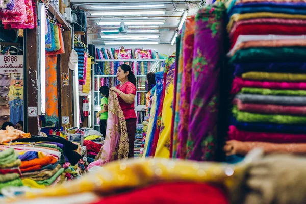 Yangon, Myanmar - 19th Şubat 2014: Bir kumaş mağazaları durak kadınlarda