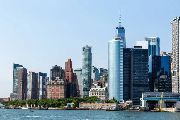Нью-Йорк / США - 14 июля 2018 года: Вид на Нижний Манхэттен с парома "Губернаторский остров" в ясный полдень — стоковое фото