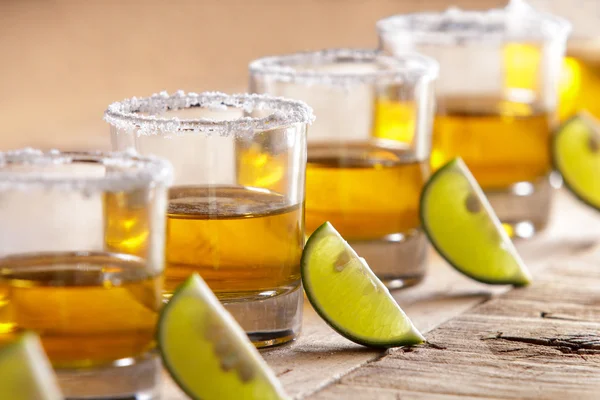 Shot di tequila di fila con fetta di lime e sale — Foto Stock