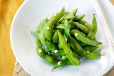 japanese food edamame nibbles, boiled green soy beans clipart