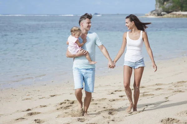 Padres e hija caminando en la playa —  Fotos de Stock