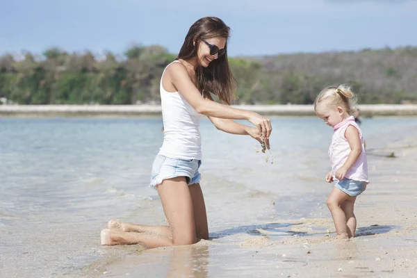 Mère avec bébé jouant avec sable mouillé — Photo