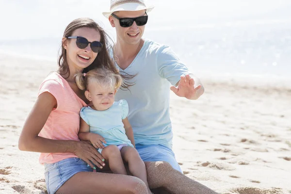 Familia sentados juntos en la playa — Foto de Stock