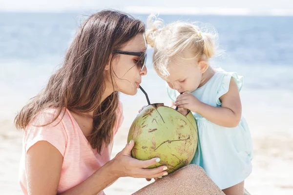 Mother sharing coconut water with daughter — Stock Photo, Image