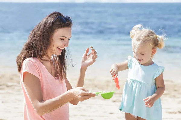 Enfant avec parent jouant des jouets de sable — Photo