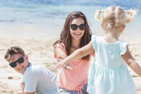 Föräldrar spelar med dotter på stranden — Stockfoto