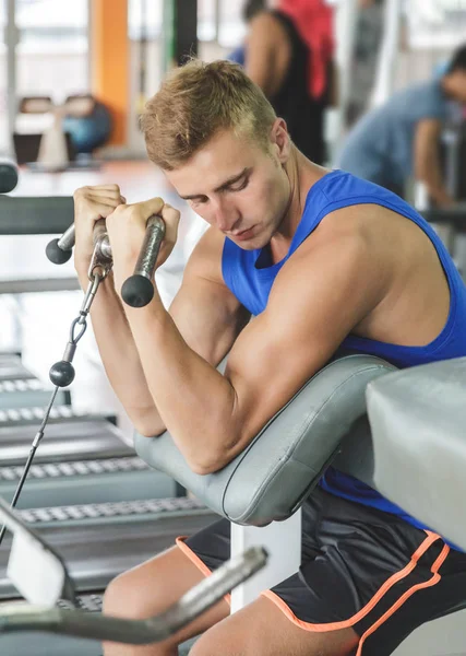 Hombre ejercitando bíceps en el gimnasio — Foto de Stock