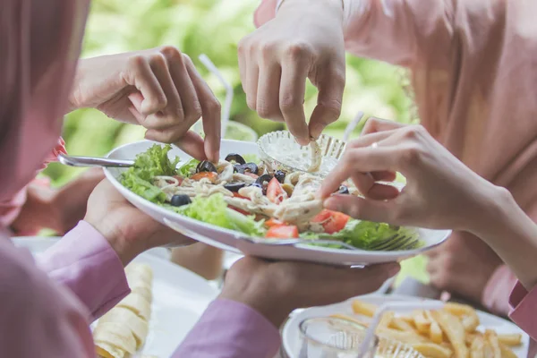 Женщины едят салат вместе с друзьями — стоковое фото
