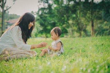 Güzel anne ve çocuğu parkta birlikte oynuyorlar.