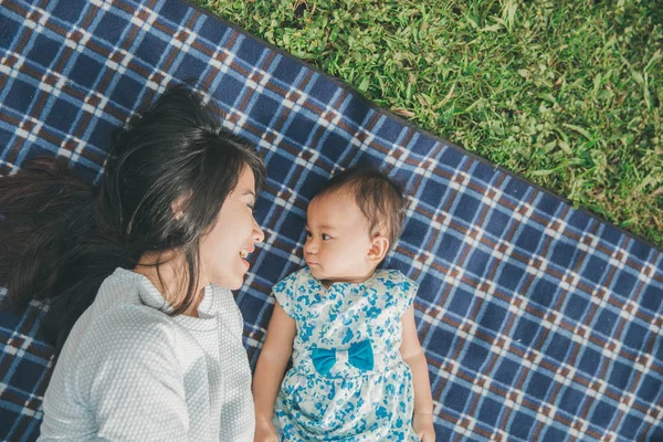 Maman et fille dans happines étendu sur une herbe — Photo