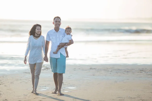 Счастливая семья из трех человек наслаждается летом на пляже — стоковое фото