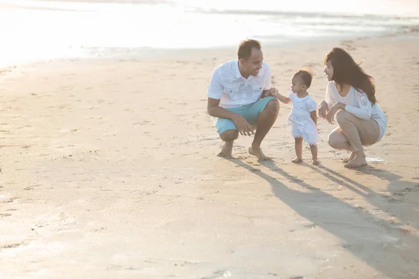 Eltern mit süßem Baby am Strand haben Spaß zusammen — Stockfoto