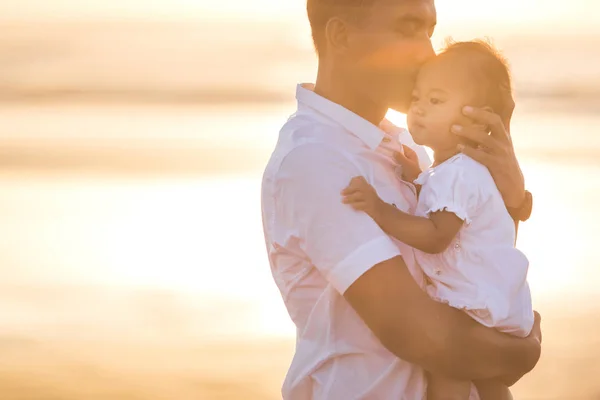 Far och lilla baby dotter på stranden vid solnedgången — Stockfoto