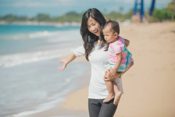 Mãe e bebê menina jogando à beira-mar — Fotografia de Stock