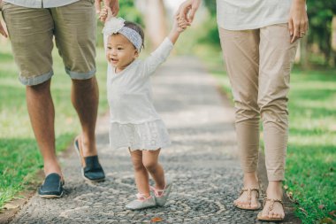 Anne ile bebek kızları parkta yürüyüş