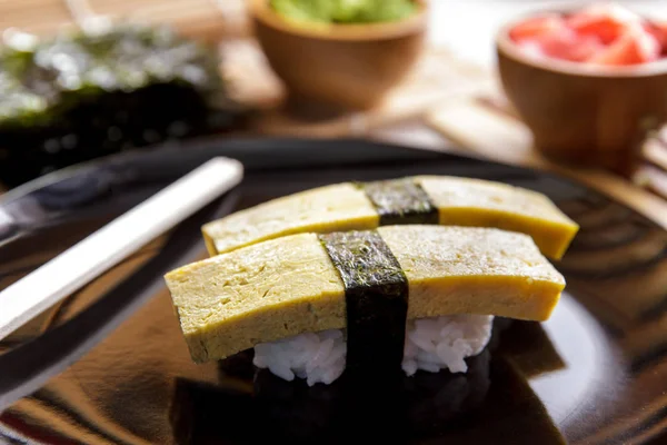 Japán élelmiszer tamago nigiri sushi a fekete lemez — Stock Fotó