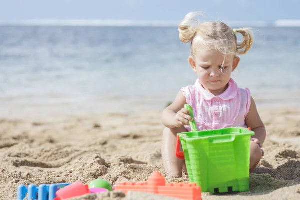 Κοριτσάκι παίζει παιχνίδια άμμου στην παραλία — Φωτογραφία Αρχείου
