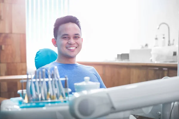 Пациент стоматолог, сидящий в стоматологическом кресле — стоковое фото