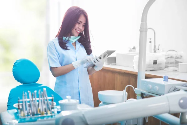 Vrouwelijk tandarts met tablet over medische kantoor kliniek — Stockfoto