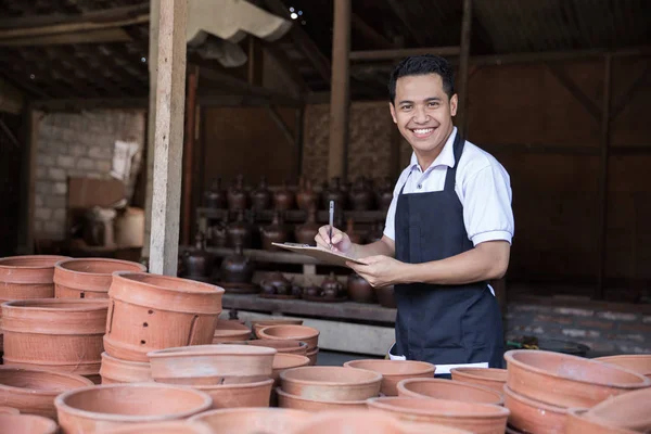 男性の陶工が彼の陶器製品のチェック — ストック写真