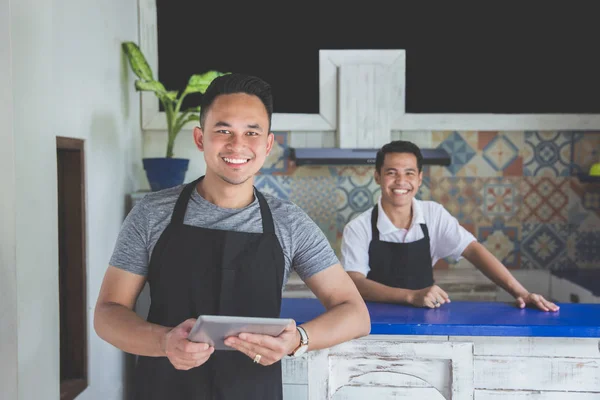 Mannelijke serveerster met behulp van digitale tablet in café — Stockfoto