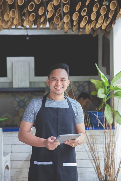 Mannelijke serveerster met behulp van digitale tablet in café — Stockfoto