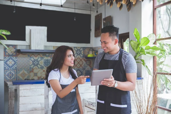 Dos trabajador de la cafetería utilizando la tableta PC juntos — Foto de Stock