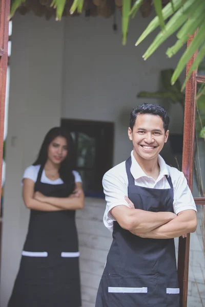 Mężczyzna kelnerka stojąc z rękami skrzyżowanymi w kawiarni — Zdjęcie stockowe