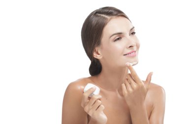 bazı yüz kremi almak gülümseyen güzel genç kadın