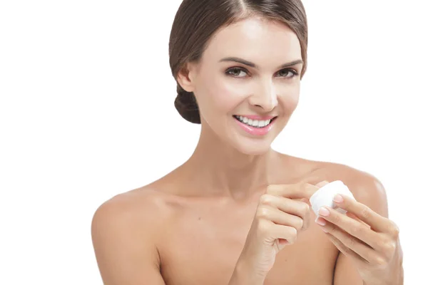Beautiful woman smiling while taking some facial cream — Stock Photo, Image