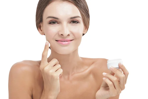 Güzel kadın gülümseyerek sırasında bazı yüz kremi uygulama — Stok fotoğraf