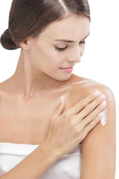 Beautiful woman applying body lotion to her arms — Stock Photo, Image
