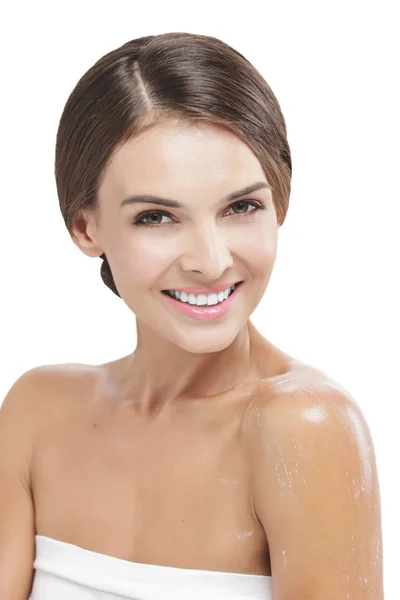 Beautiful woman smiling with some body lotion on her arms — Stock Photo, Image