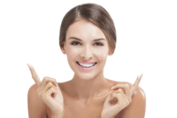 Hermosa mujer sonriendo con un poco de crema facial en los dedos — Foto de Stock
