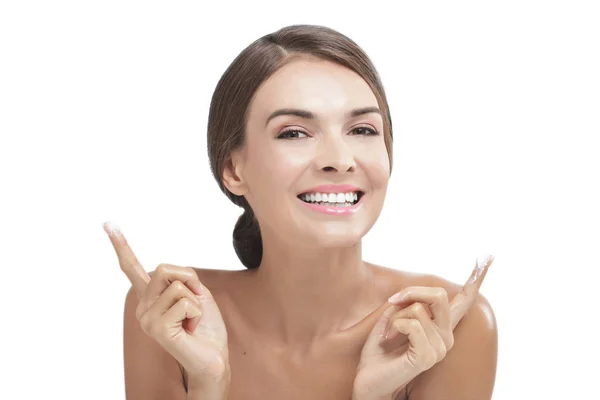 Beautiful woman smiling with some facial cream on her fingers — Stock Photo, Image