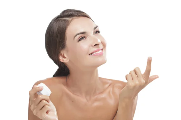 Beautiful young woman smiling while take some facial cream — Stock Photo, Image