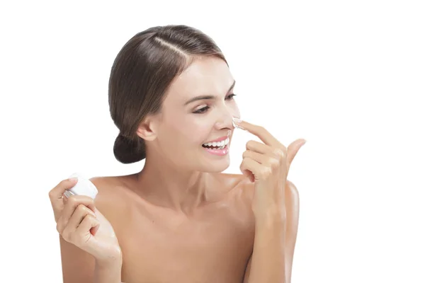 Beautiful young woman smiling while take some facial cream — Stock Photo, Image